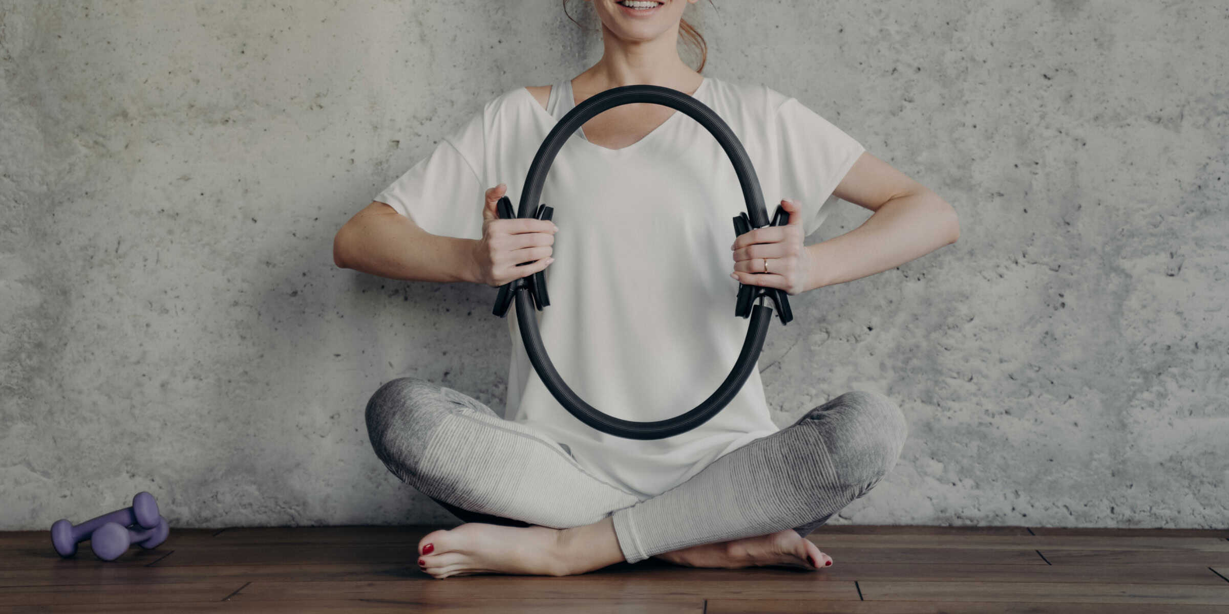 woman squeezing pilates ring