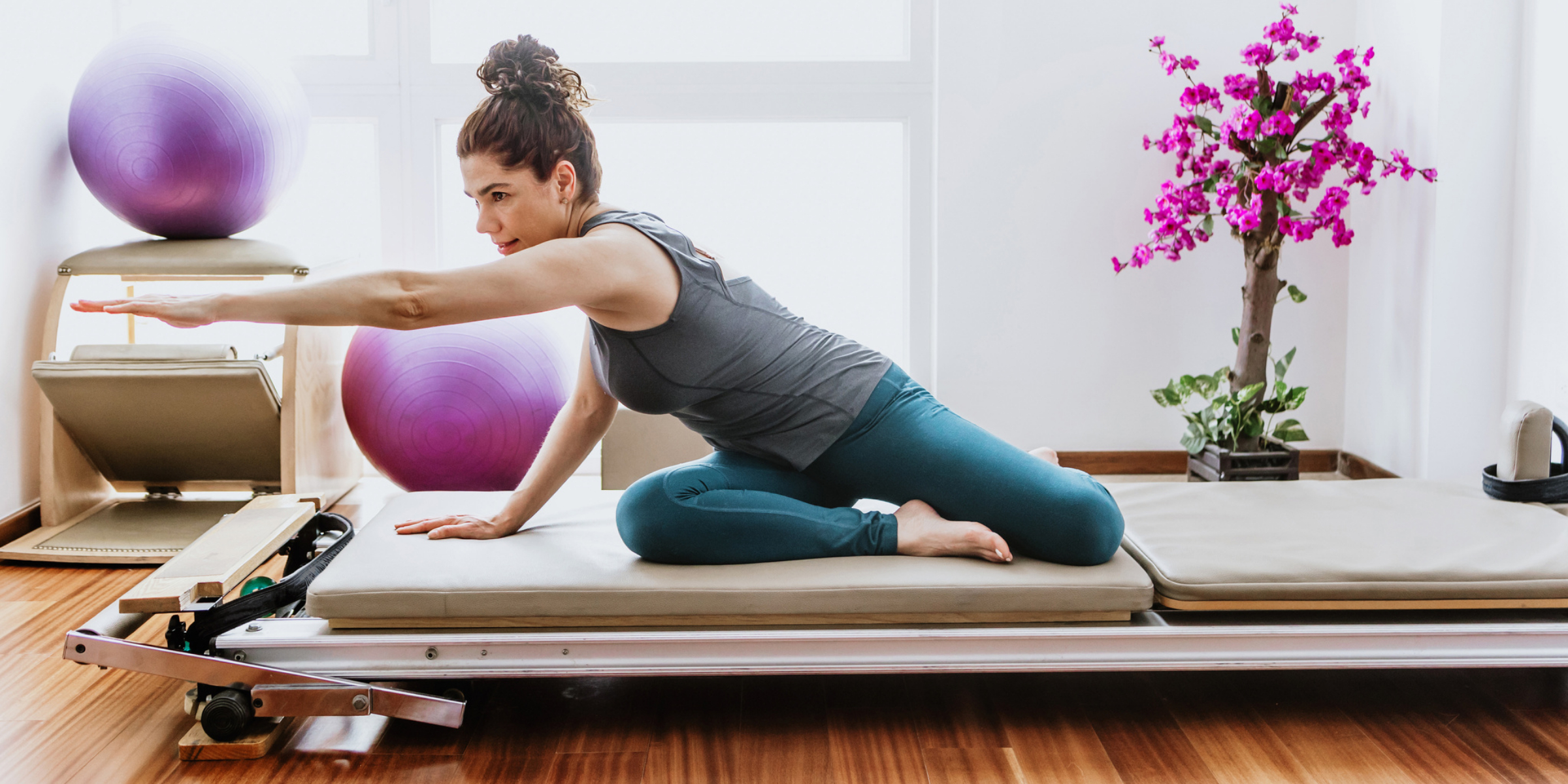 A woman doing pilates on a pilates reformer.