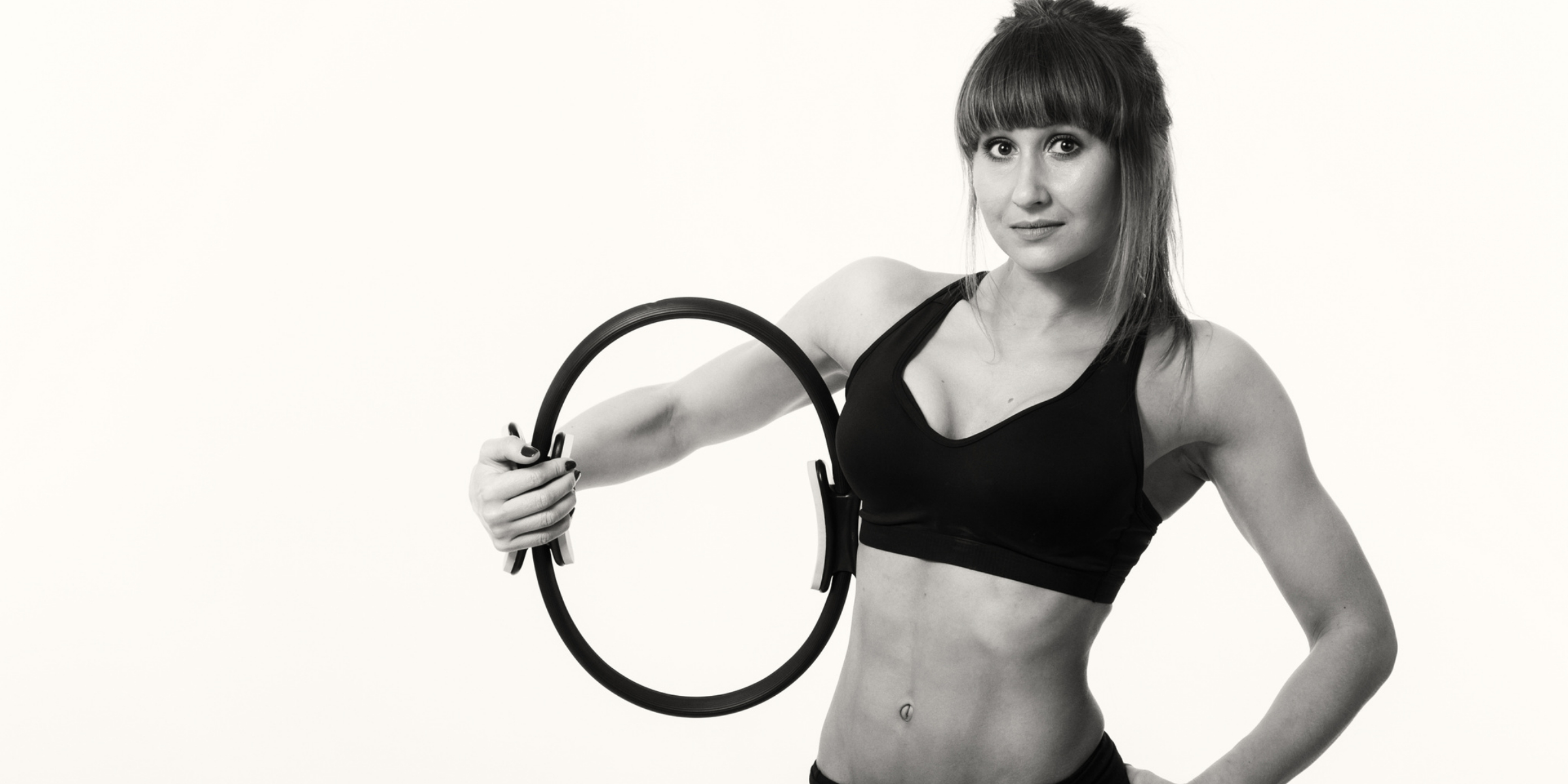 A woman is holding a Pilates ring.
