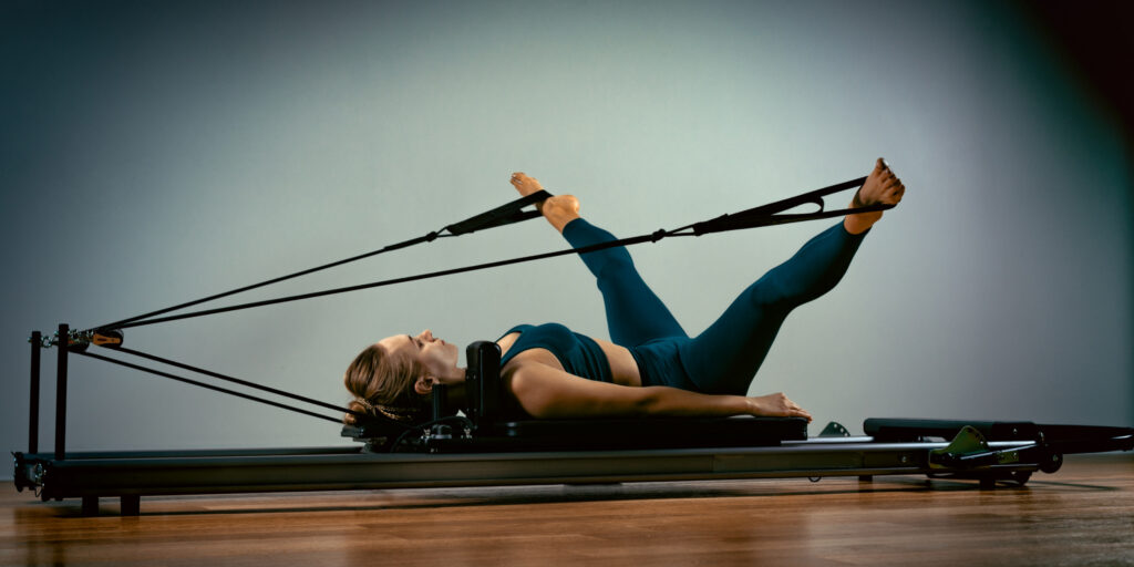 woman doing y shape on reformer