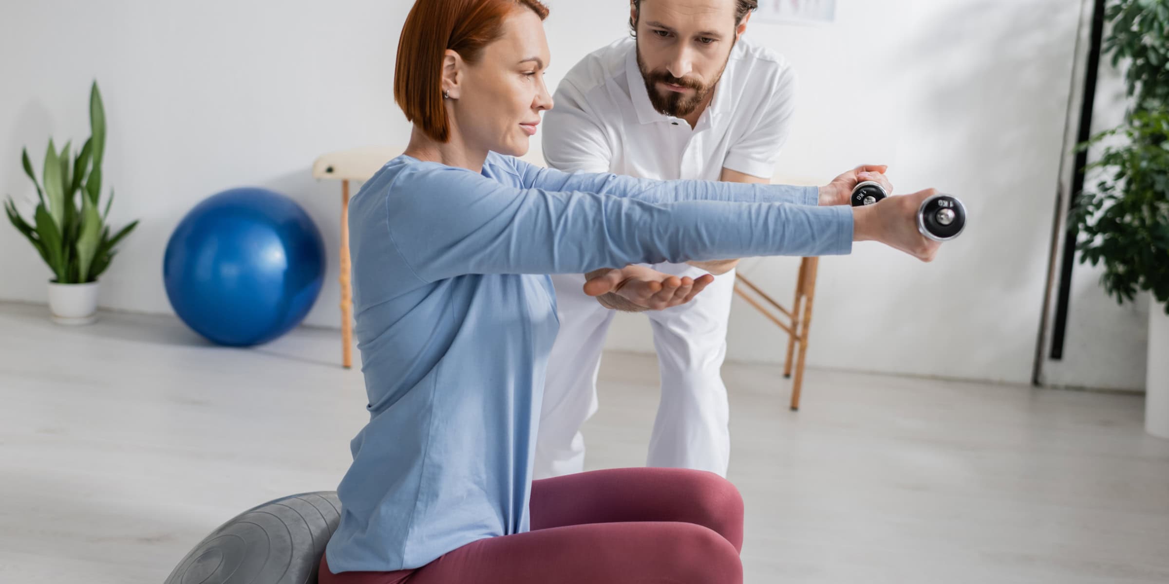 A woman and a man doing exercises in a gym.