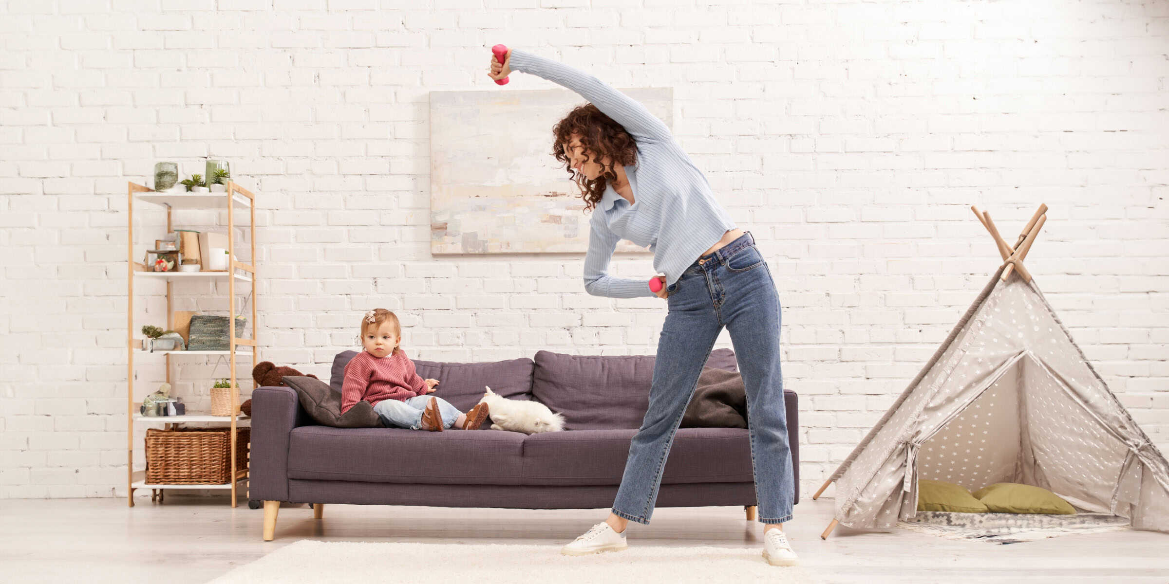 A woman and a child are sitting on a couch in front of a teepee.