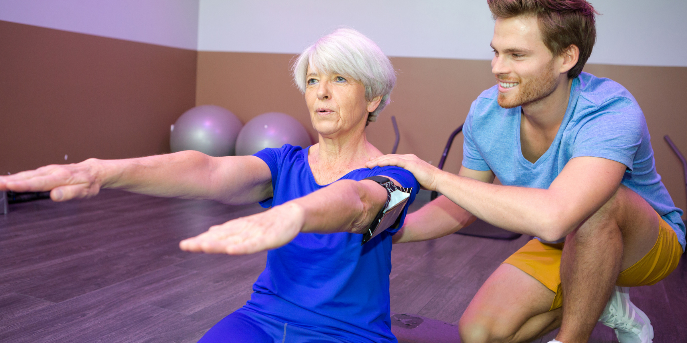 A woman and a man doing exercises in a gym.