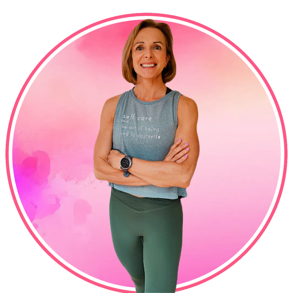 A woman in a green tank top and leggings standing in front of a pink background.