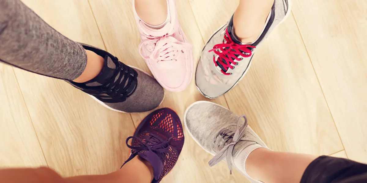 A group of people standing in a circle with their shoes on.